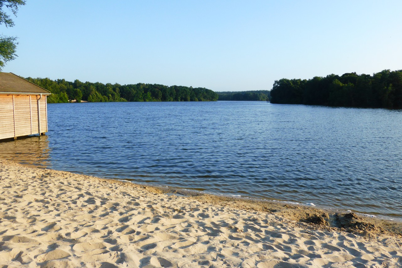 Blick auf die Talsperre mit Sandstrand im Vordergrund